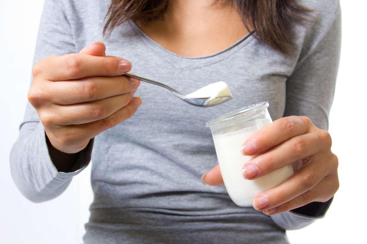 Mujer con un yogur en la mano - Freepik